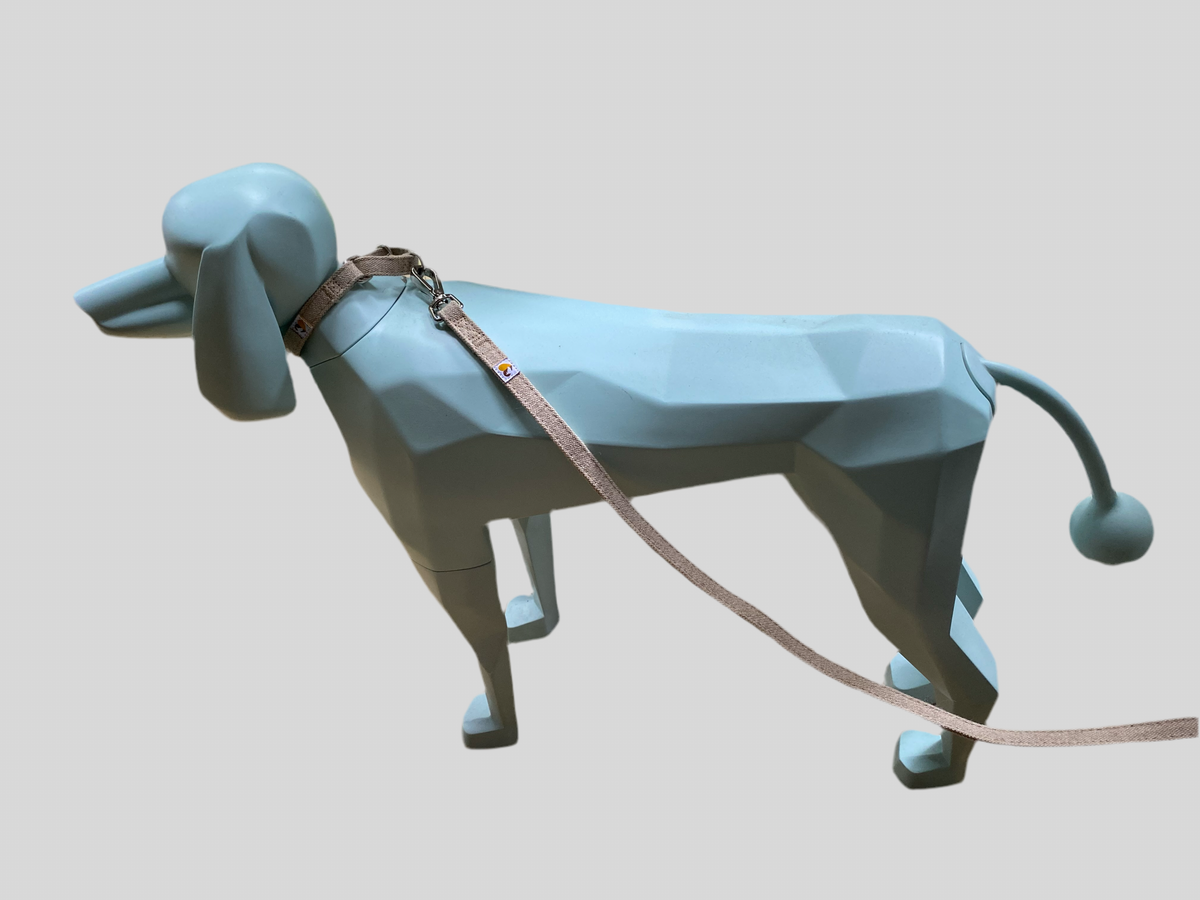Natural hemp dog collar and lead on a light blue geometric dog figurine.