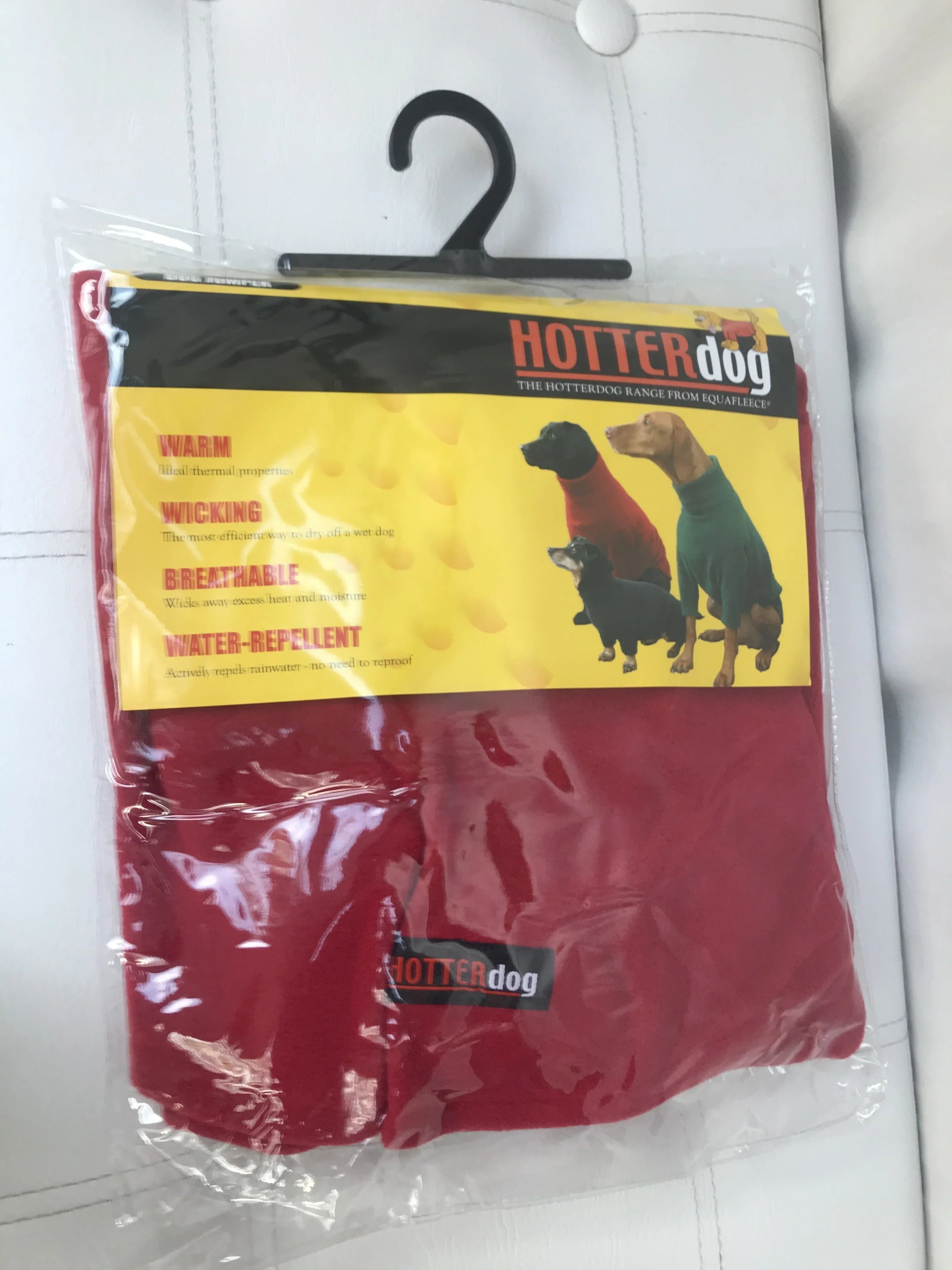 Red Hotterdog fleece dog jumper in original plastic packaging on a black hanger.