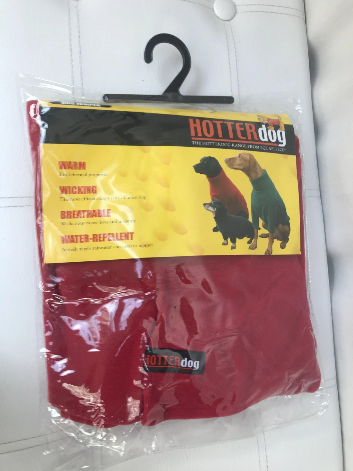 Red Hotterdog fleece dog jumper in original plastic packaging on a black hanger.
